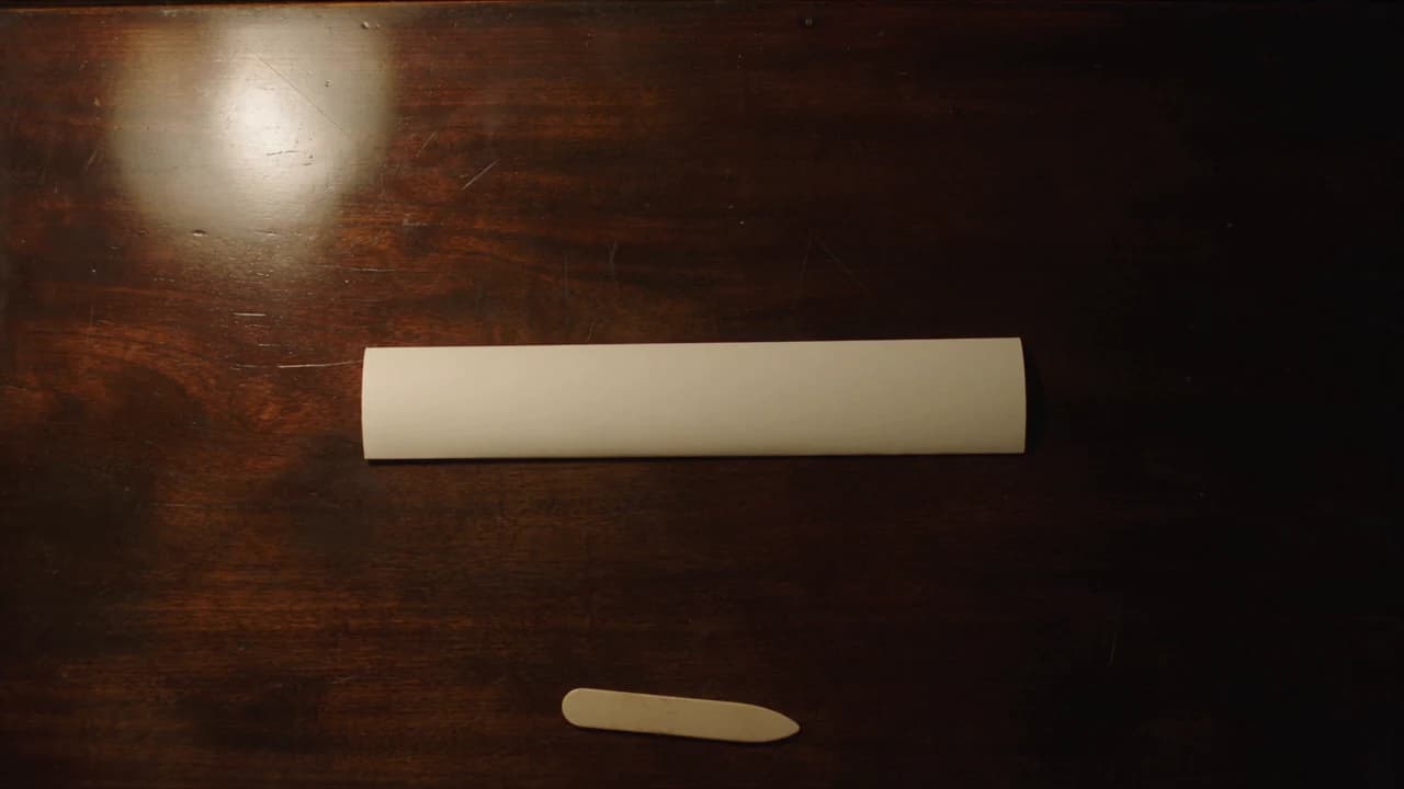 Seedance 2.5 second run at 5.7 seconds: narrow closed paper and an extra bone-folder tool
